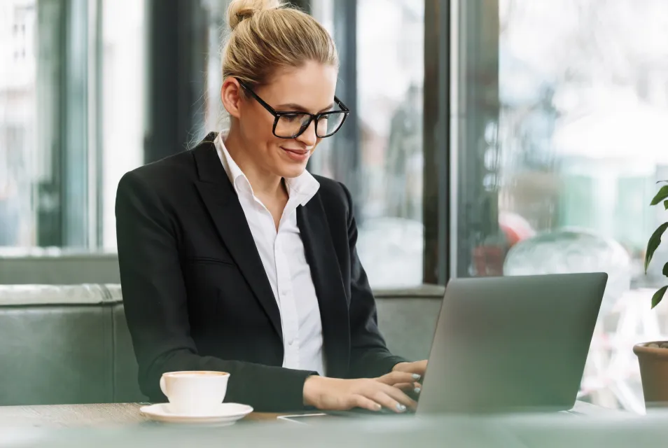 Agentica sa naočalama radi na laptopu u kancelariji